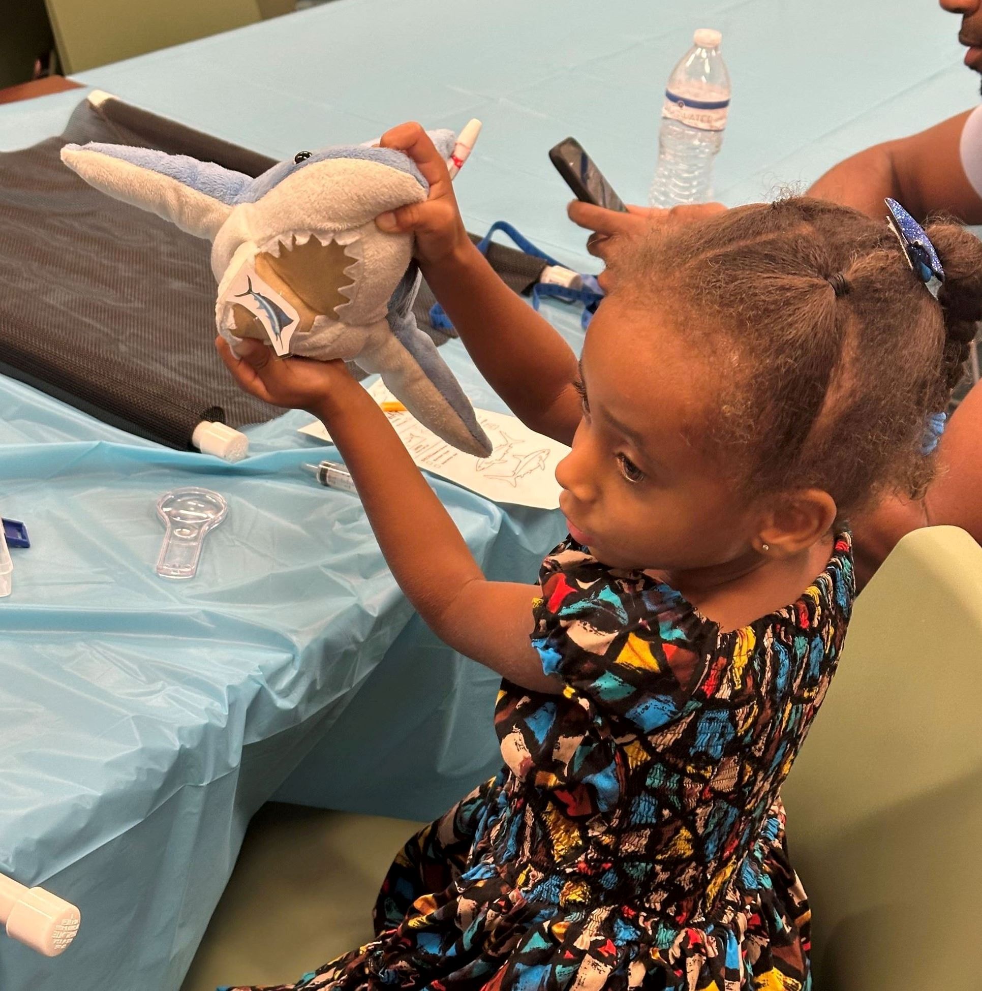 Little girl holding stuffed animal shark