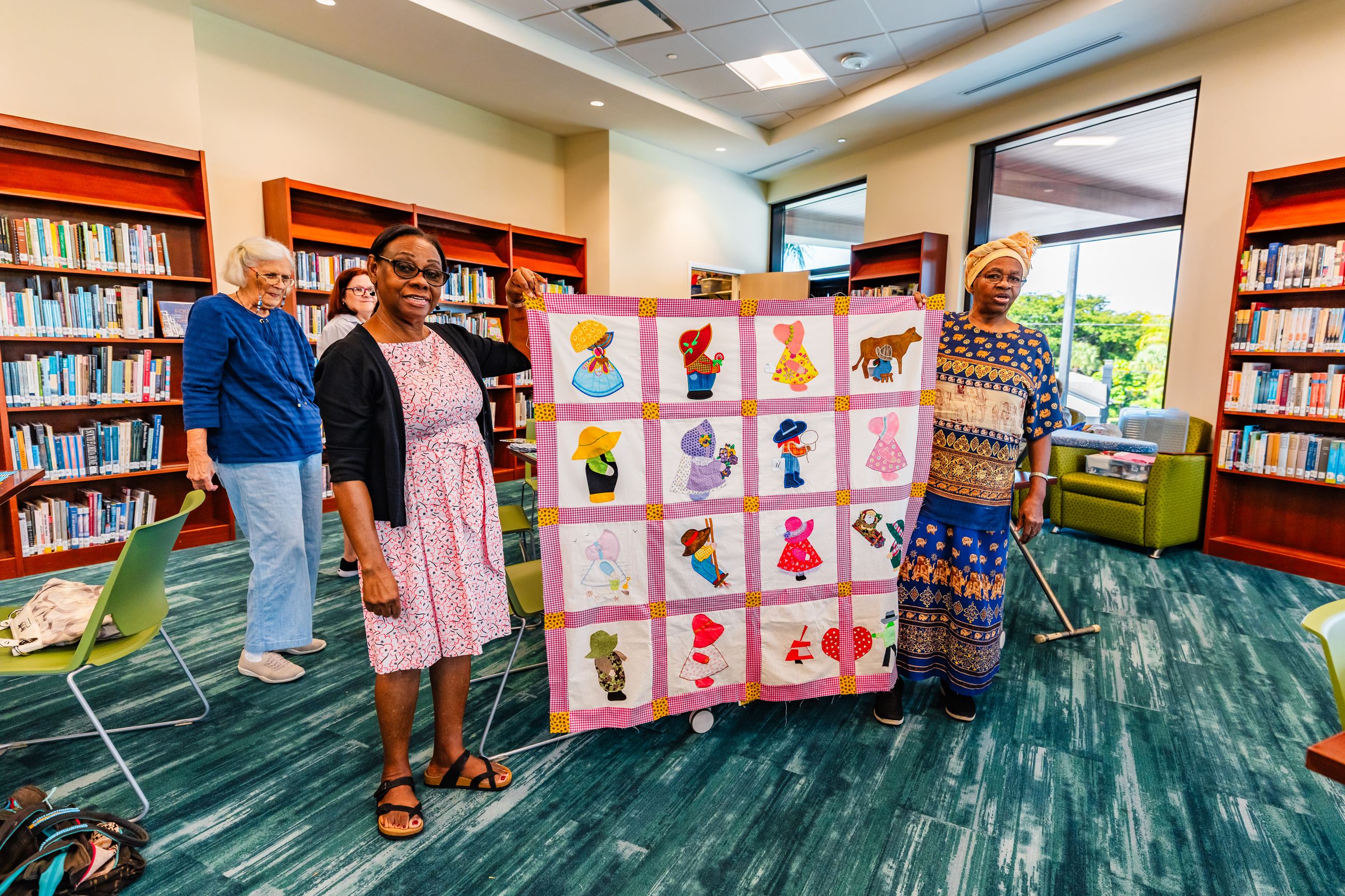 Two women holding up a quilt