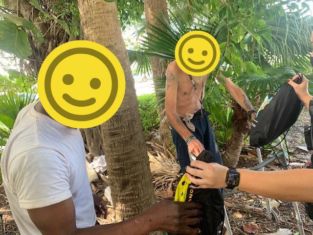 Two Homeless Men Being Given Care Bags